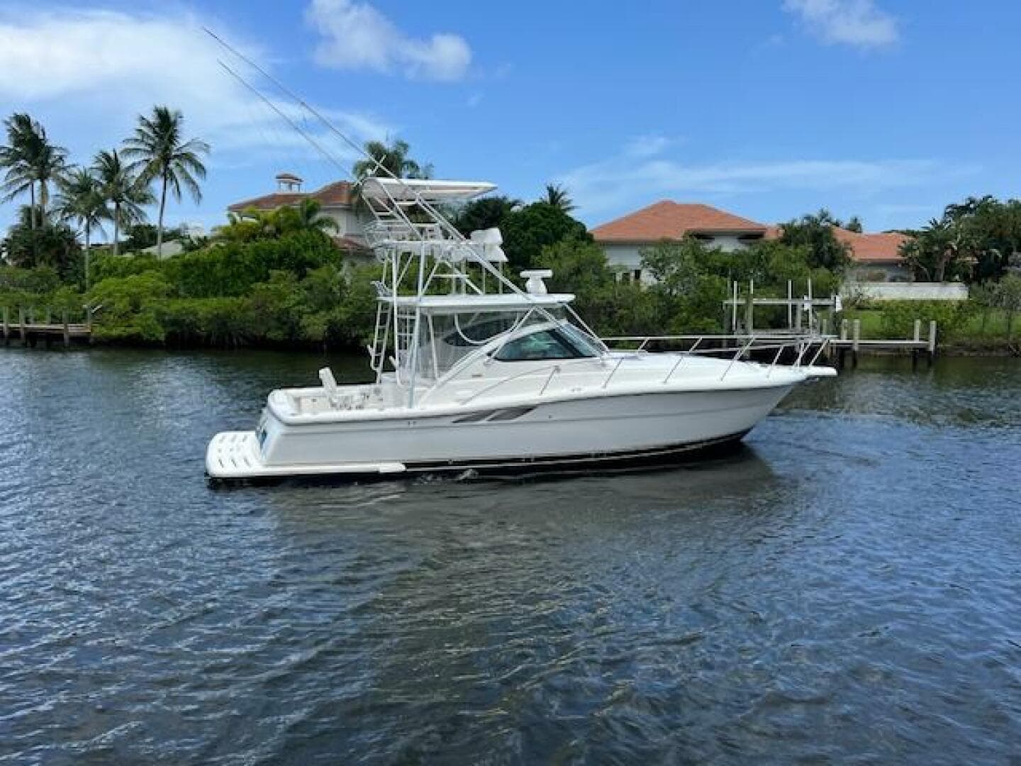 2003 Tiara Yachts 3800 Open cruising on a scenic waterway with palm trees.