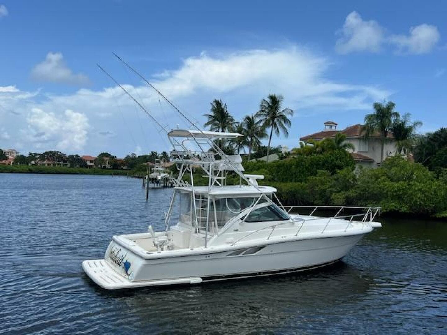2003 Tiara Yachts 3800 Open on a serene waterway, surrounded by lush greenery.