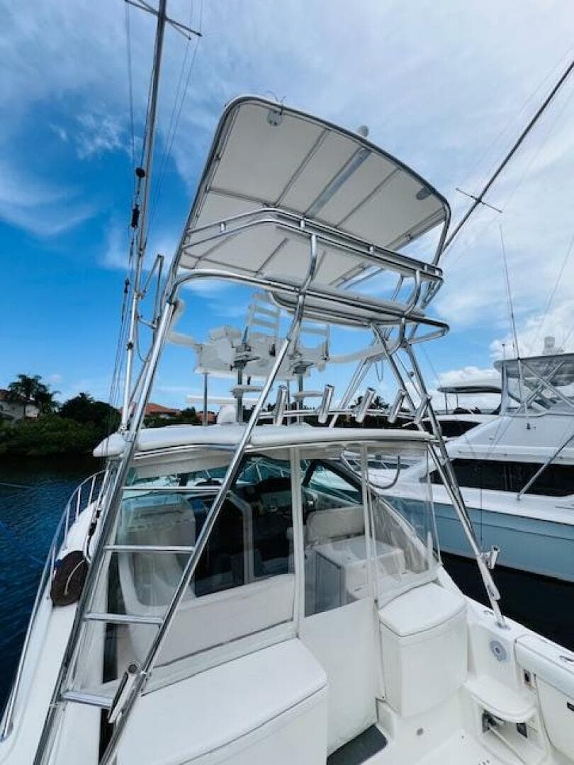 2003 Tiara Yachts 3800 Open with tower, docked under blue sky.