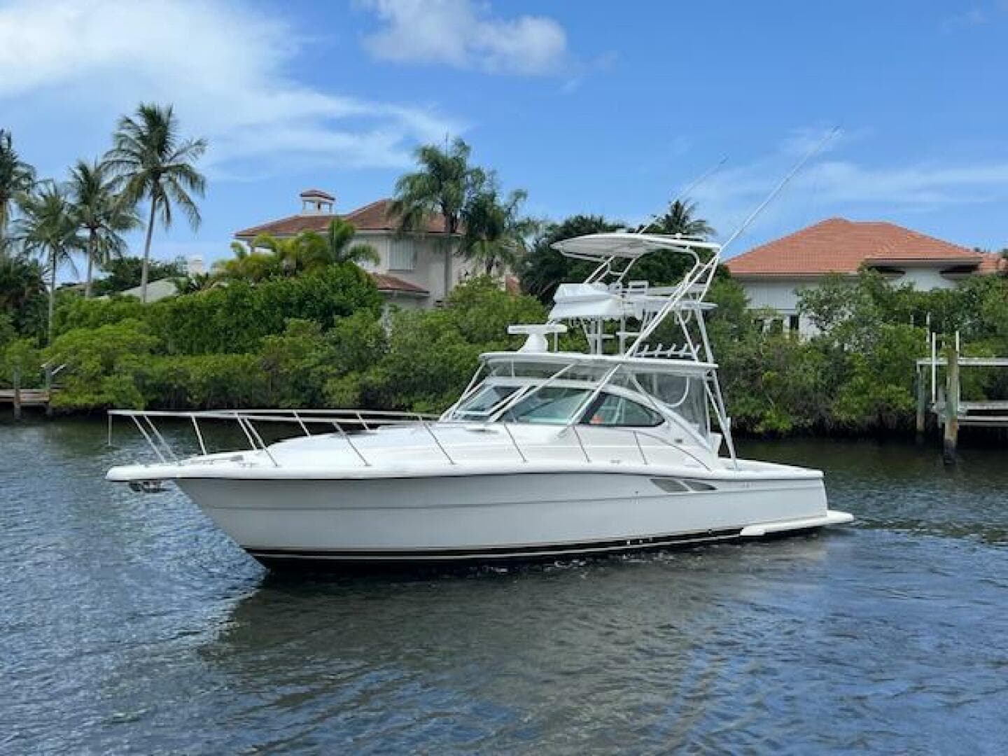 2003 Tiara Yachts 3800 Open cruising on a scenic waterway with palm trees.