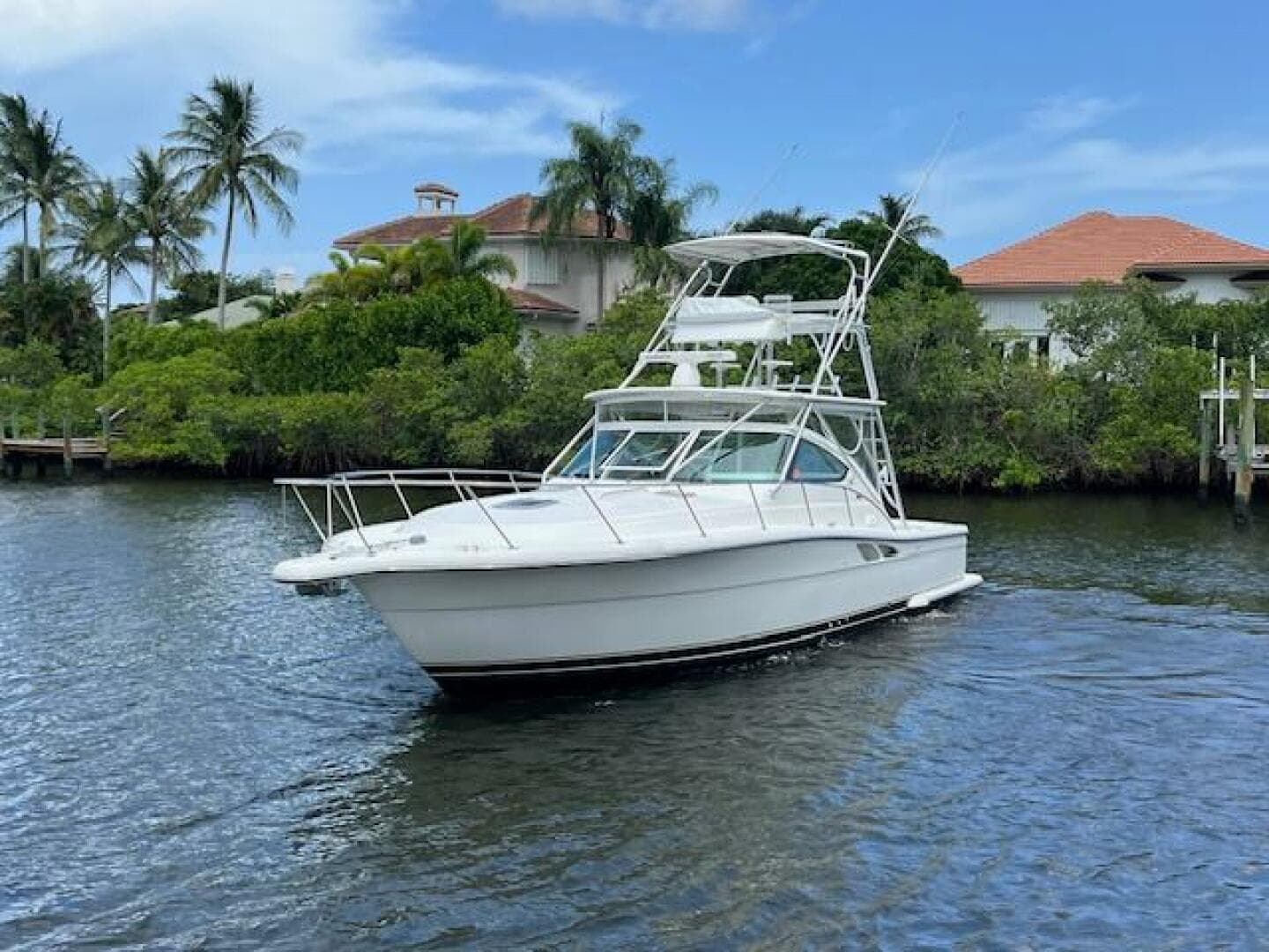 2003 Tiara Yachts 3800 Open cruising on a scenic waterway with palm trees.