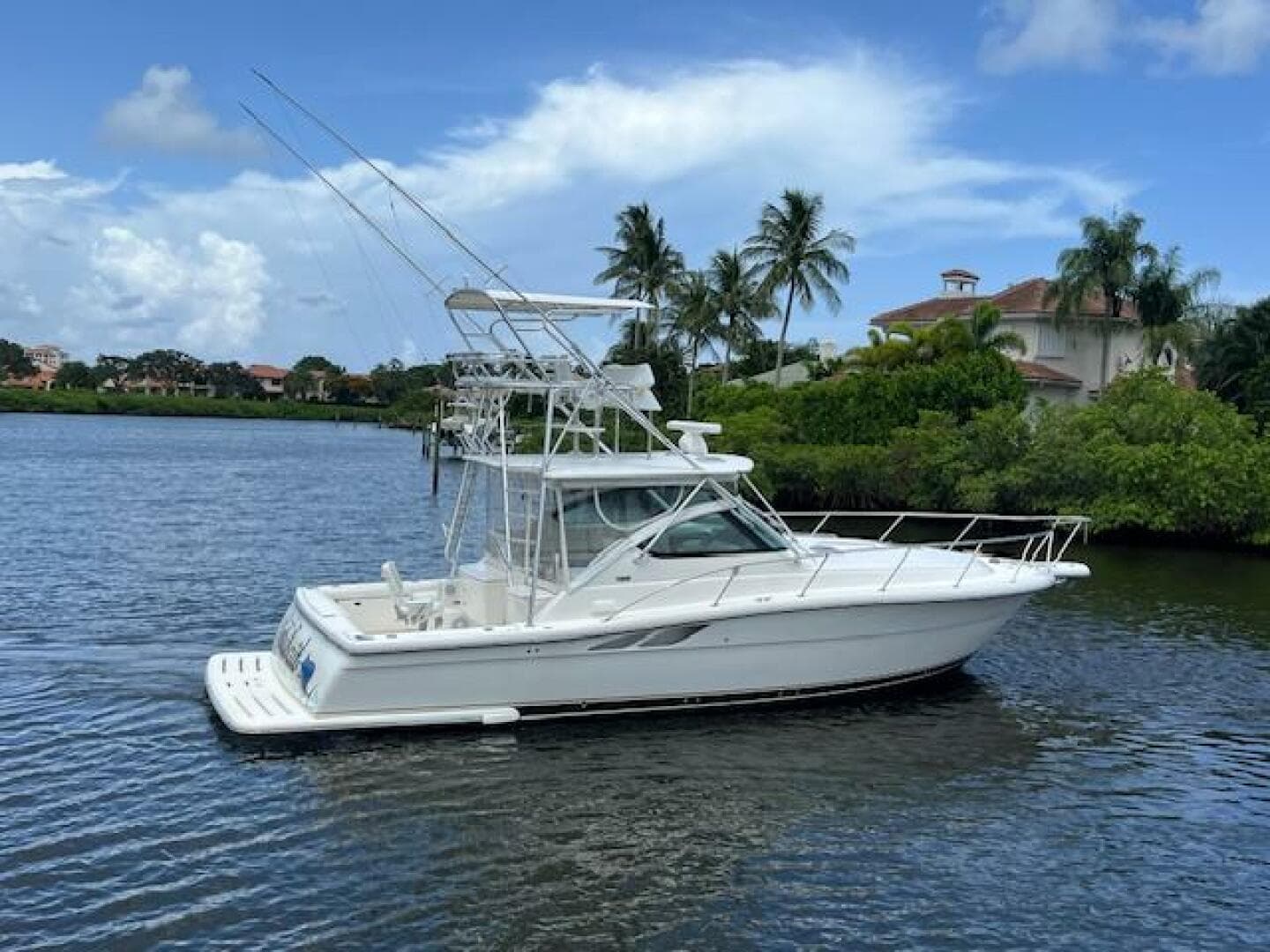 2003 Tiara Yachts 3800 Open on a scenic waterway with palm trees.