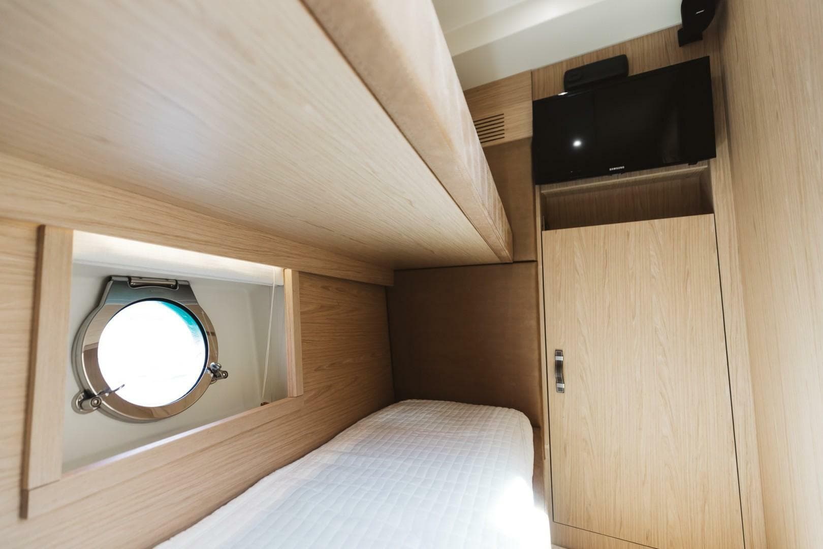 Interior cabin of 2015 Beneteau Monte Carlo 5 yacht with porthole and TV.