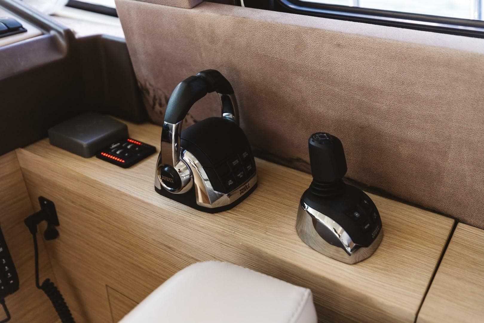 2015 Beneteau Monte Carlo 5 yacht controls with joystick and throttle on wooden console.