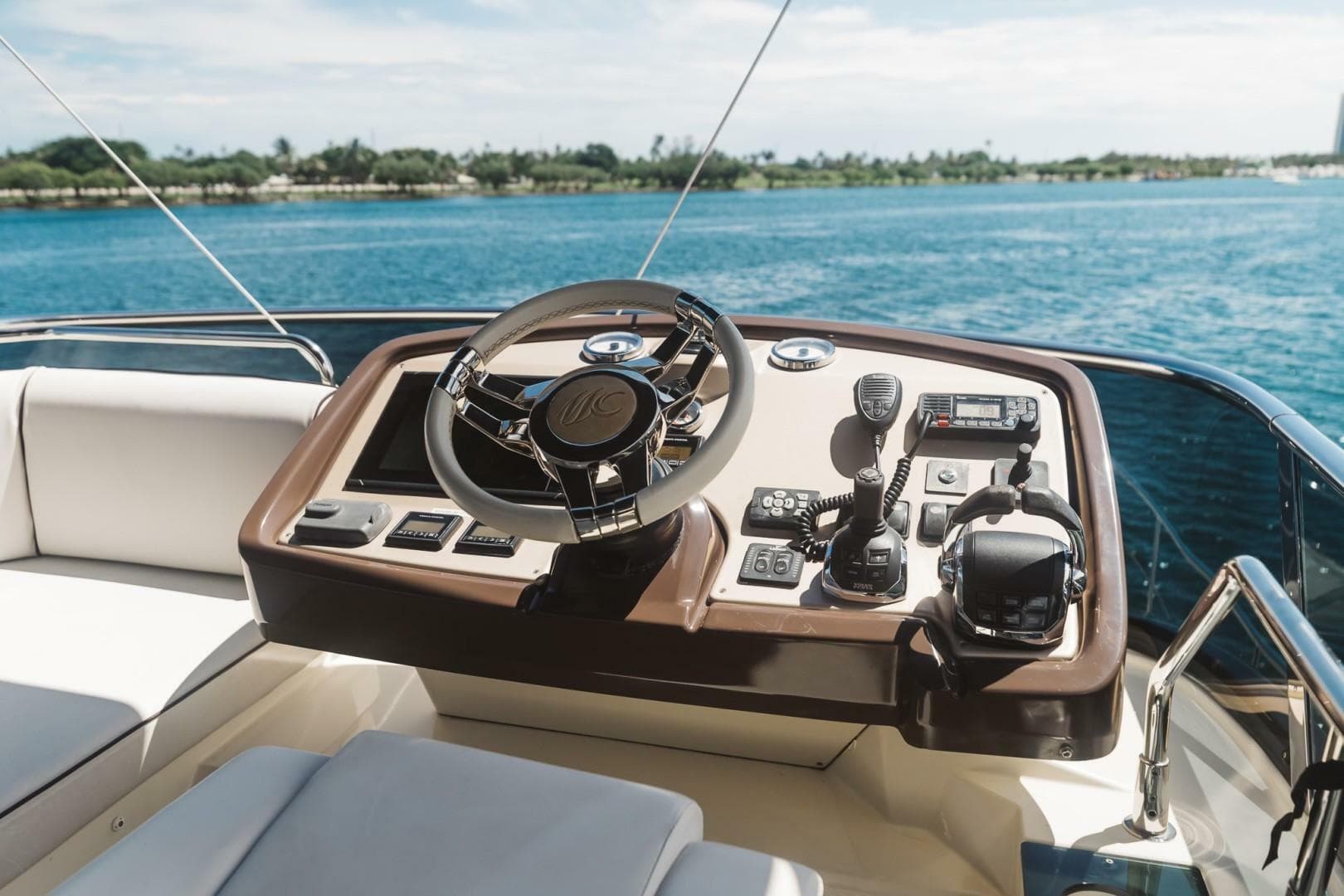 Beneteau Monte Carlo 5 yacht helm, 2015 model, overlooking serene blue waters.