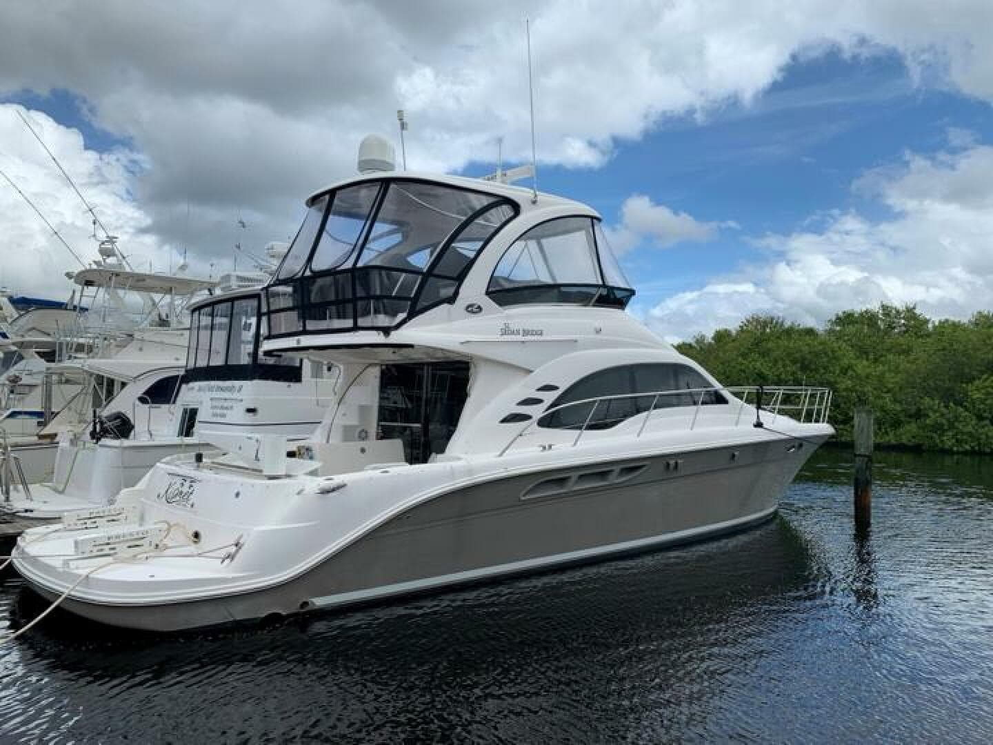 2006 Sea Ray 52 Sedan Bridge yacht docked in a marina.