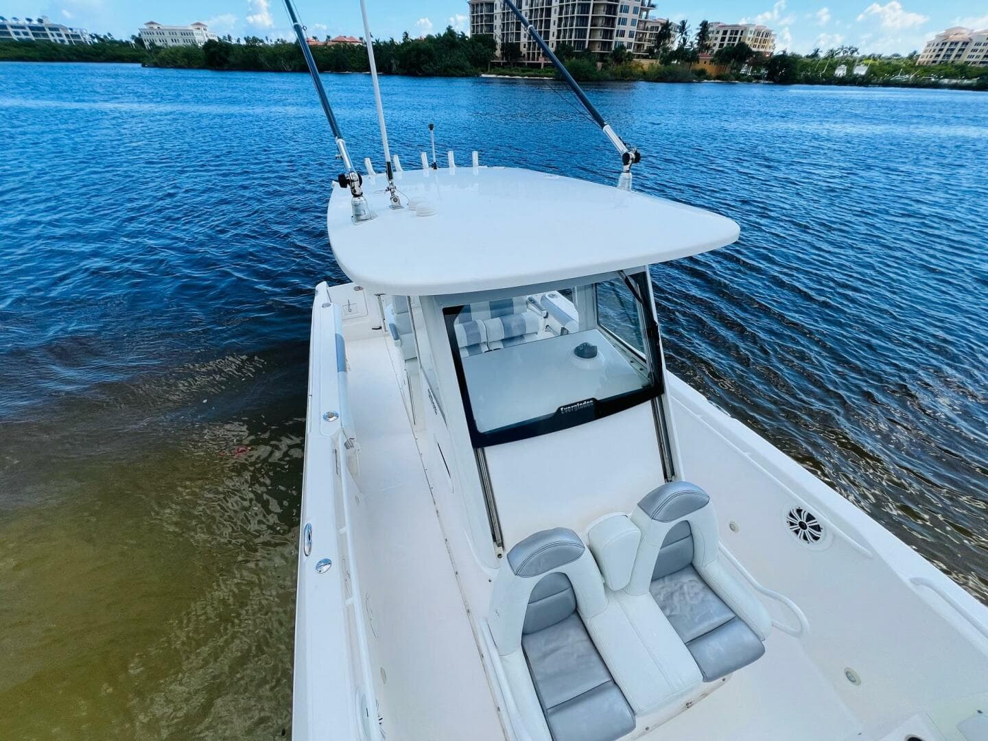 2012 Everglades 295 Center Console boat on calm water, featuring sleek design and fishing rods.