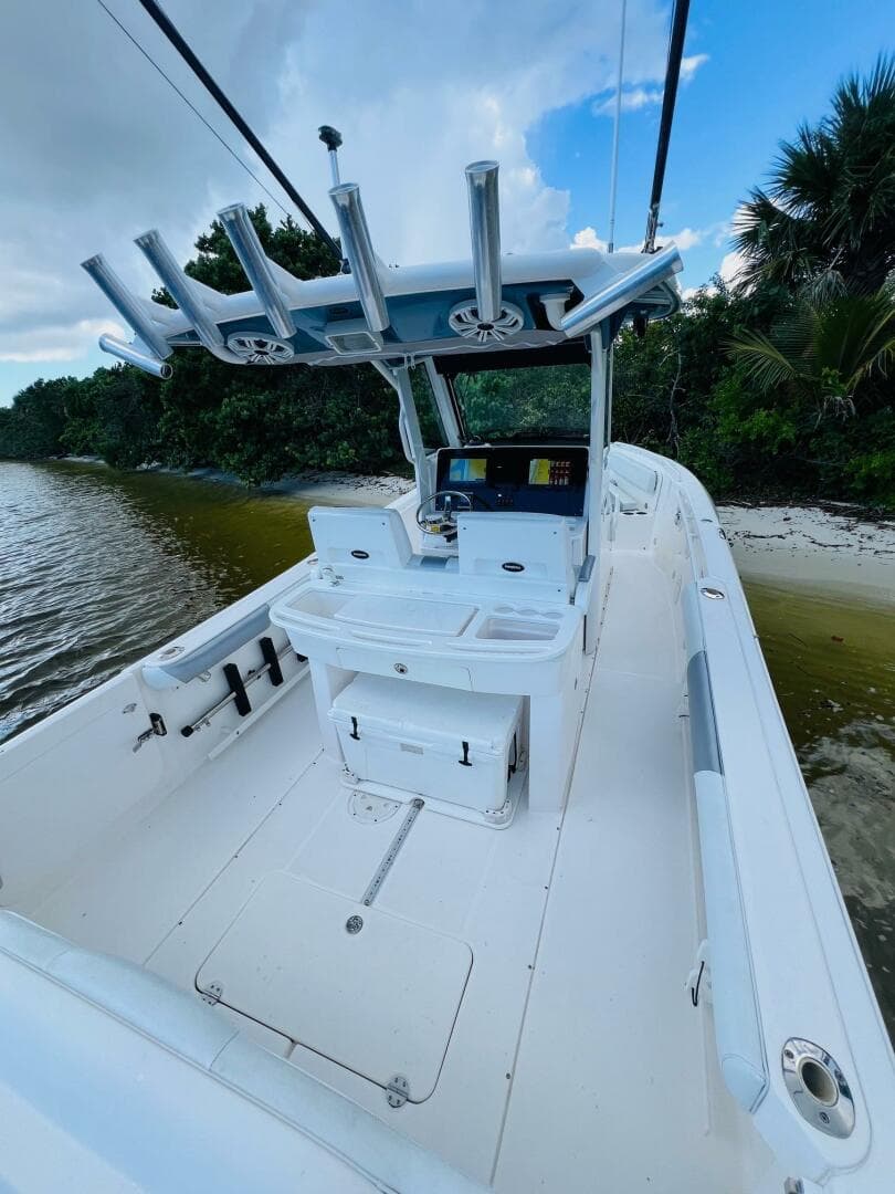 2012 Everglades 295 Center Console boat on a serene shoreline.