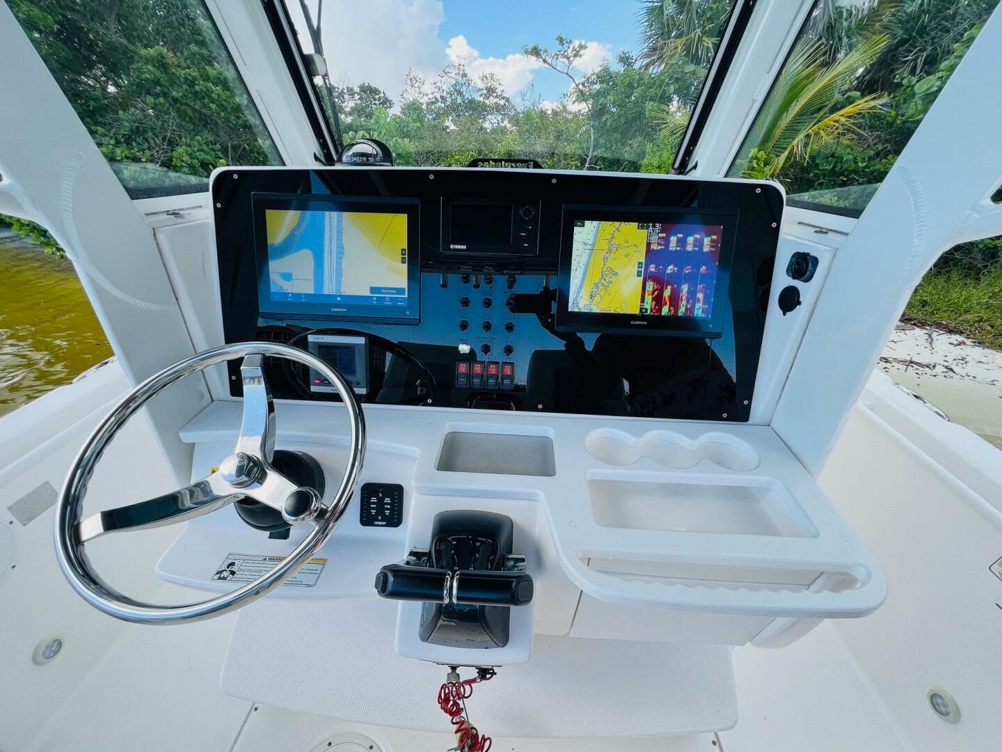 2012 Everglades 295 Center Console boat dashboard with navigation screens and steering wheel.
