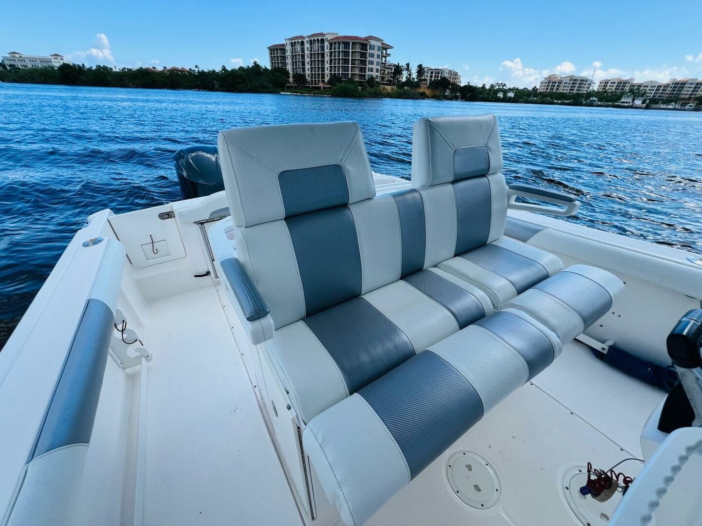 2012 Everglades 295 Center Console boat with striped seating, on a calm waterfront.