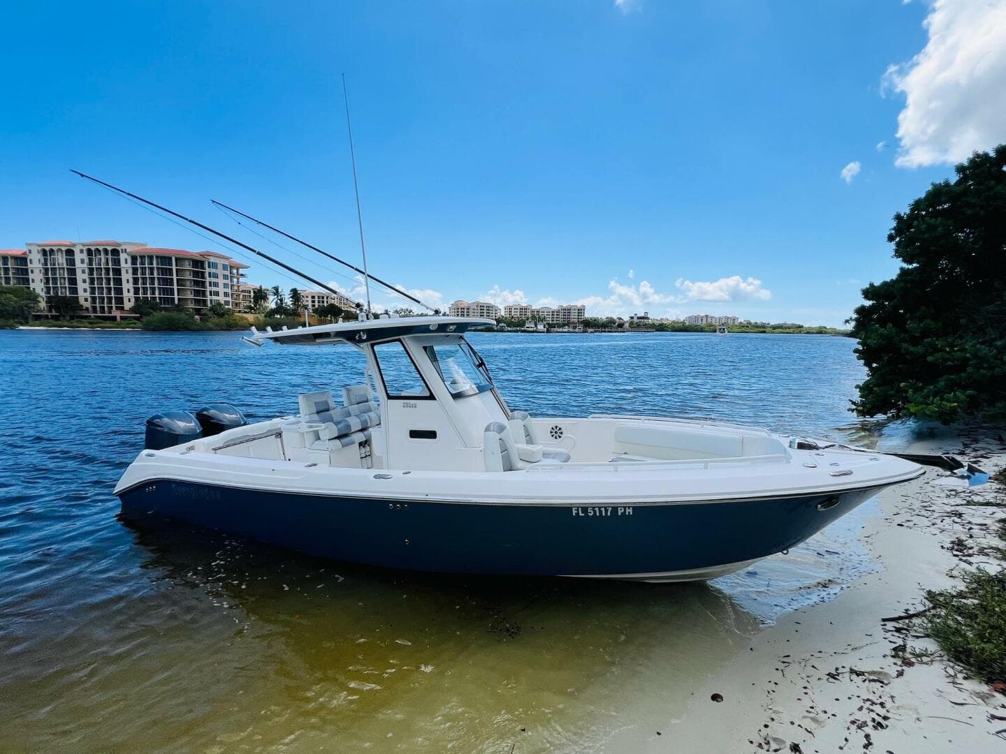 2012 Everglades 295 Center Console boat on sandy shore, clear blue sky.