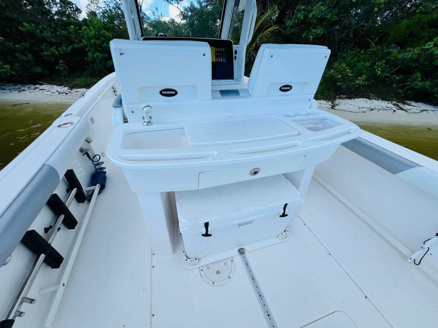 2012 Everglades 295 Center Console boat interior with seating and storage, near a sandy shore.