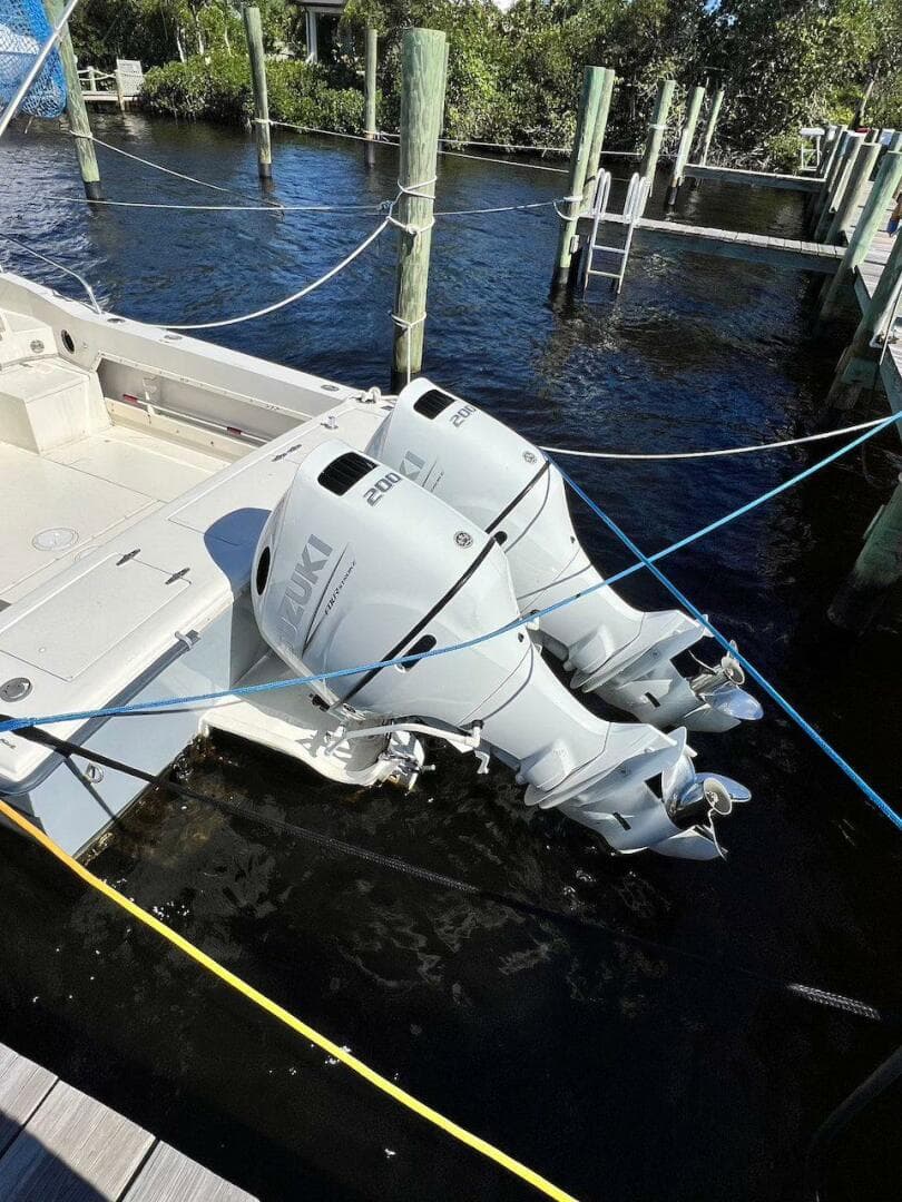 1988 Grady-White 25 Sailfish boat with dual outboard engines docked in marina.
