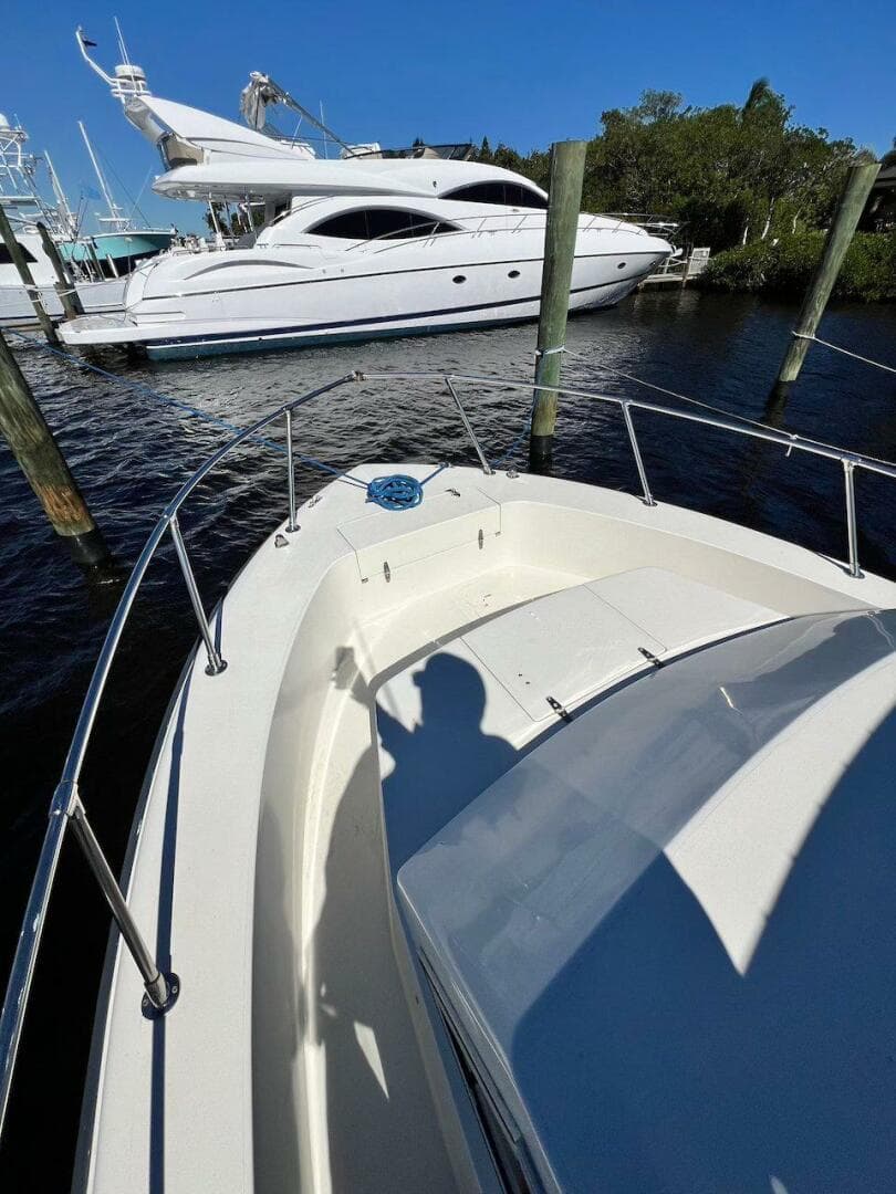 1988 Grady-White 25 SAILFISH boat docked near a luxury yacht.