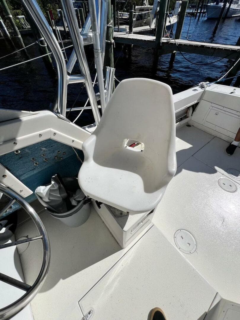 1988 Grady-White 25 Sailfish boat cockpit with white captain's chair and steering wheel.