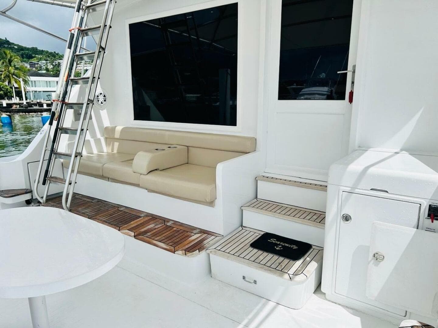 1988 Bertram 54' yacht deck with seating, ladder, and steps in a marina setting.