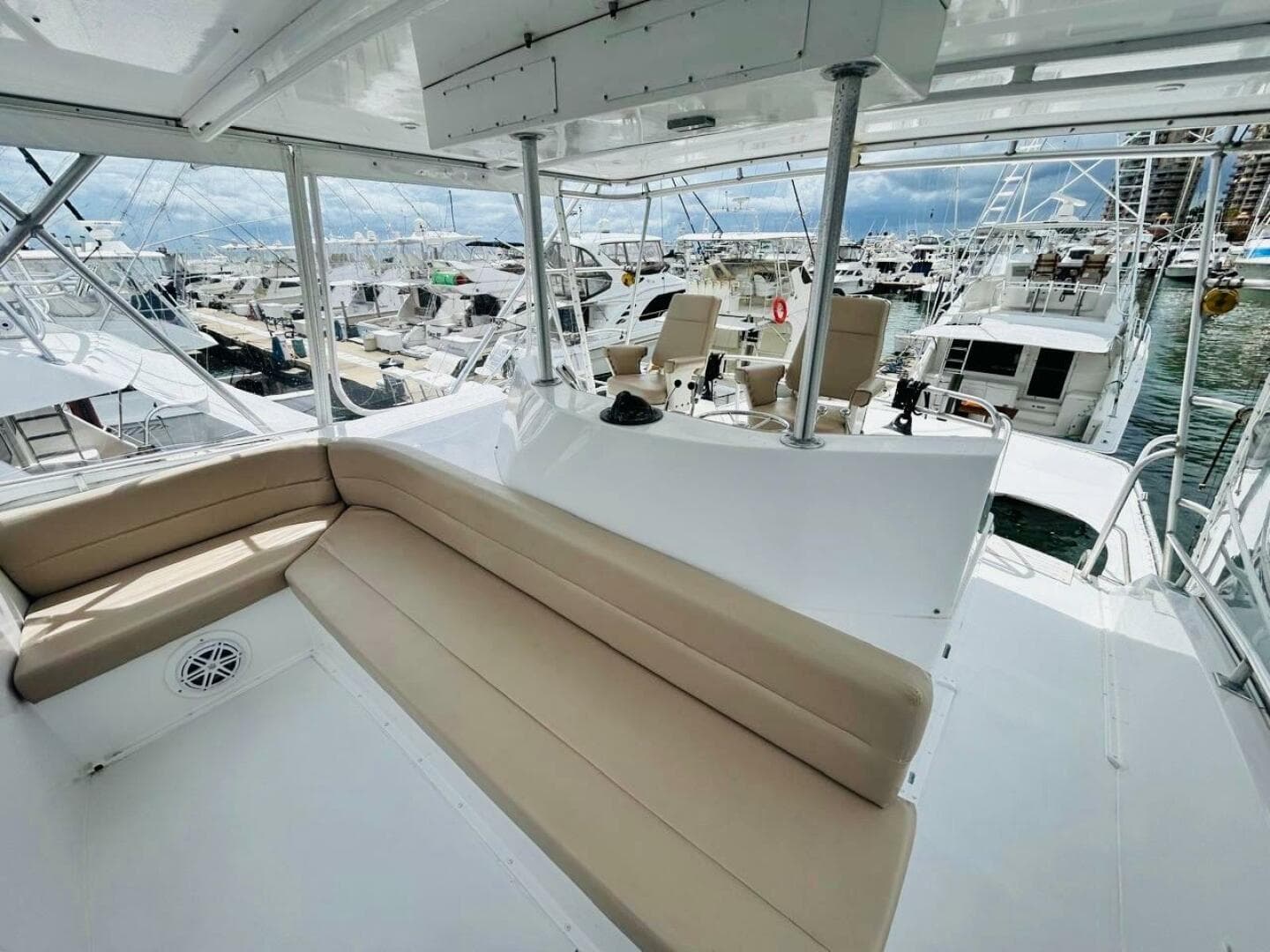1988 Bertram 54' yacht interior with seating, docked among other boats.