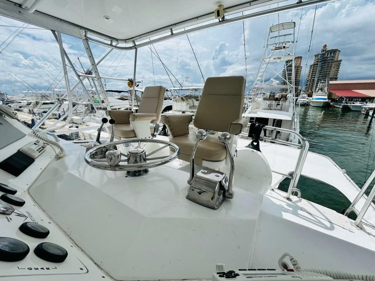 1988 Bertram 54' yacht helm with dual captain chairs at marina.