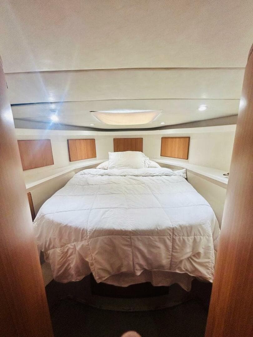 Luxurious bedroom interior of 1988 Bertram 54' yacht with cozy bedding.