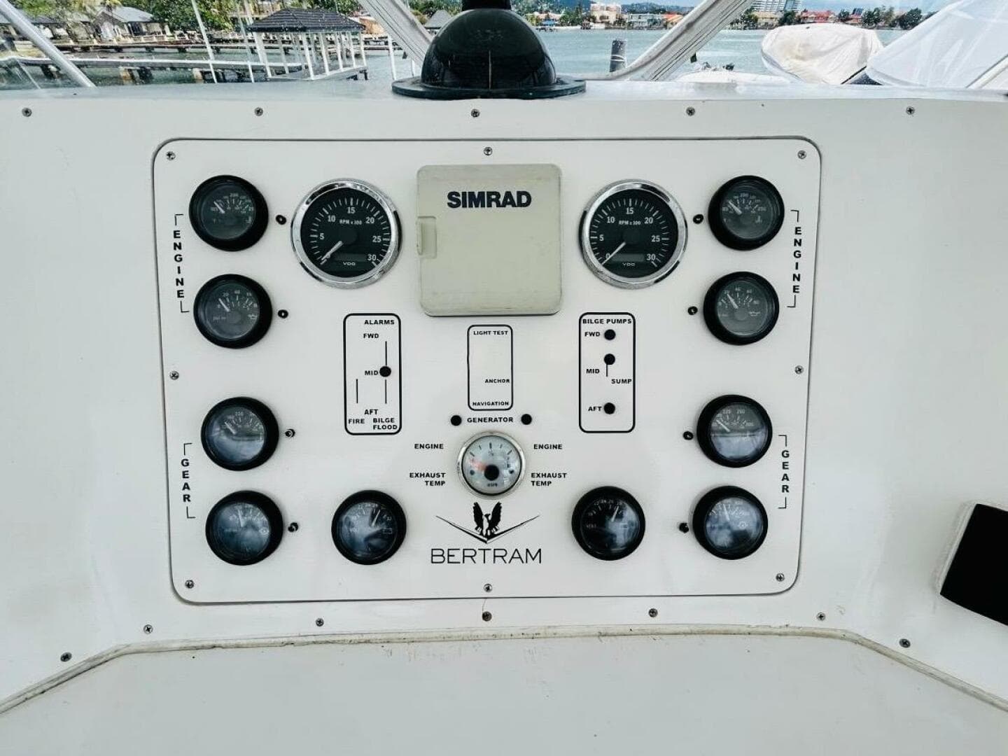 Control panel of a 1988 Bertram 54' yacht with gauges and Simrad equipment.