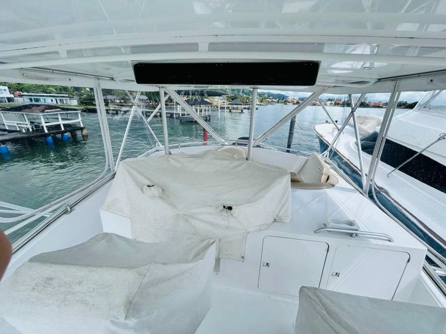 1988 Bertram 54' yacht deck with covered seating, docked at marina.