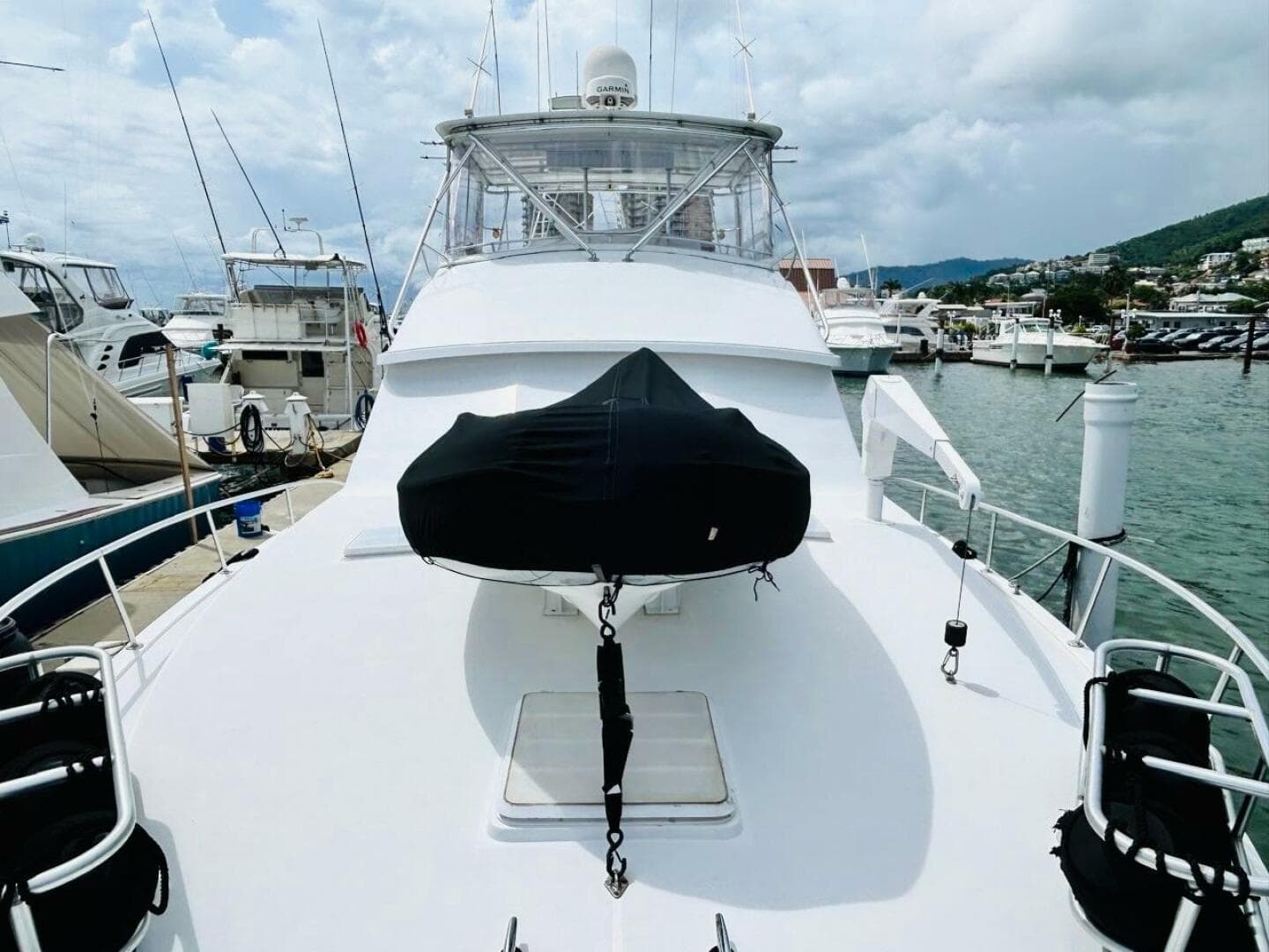 1988 Bertram 54' yacht docked at marina, featuring spacious deck and covered equipment.