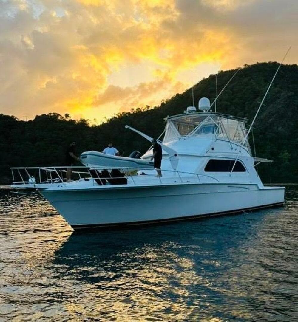 1988 Bertram 54' yacht at sunset on tranquil waters.