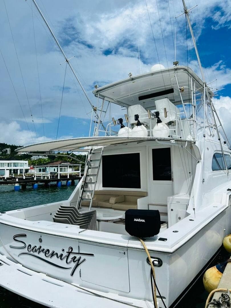 1988 Bertram 54' yacht docked, featuring spacious deck and fishing equipment.