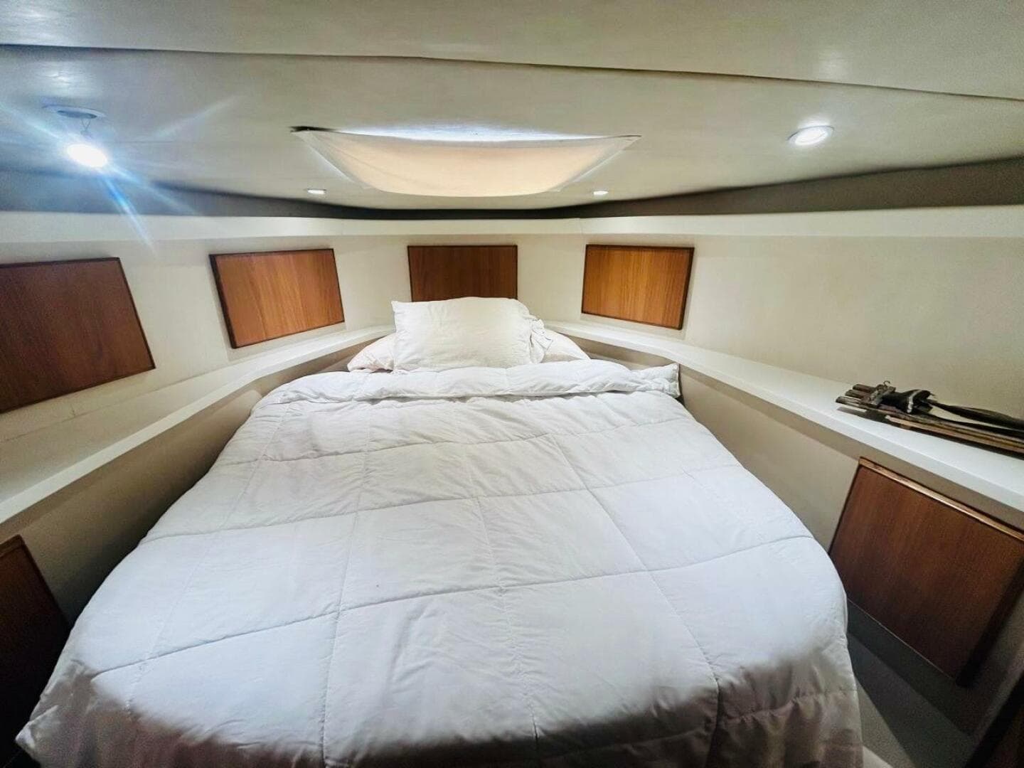 Luxurious bedroom interior of 1988 Bertram 54' yacht with cozy bedding.