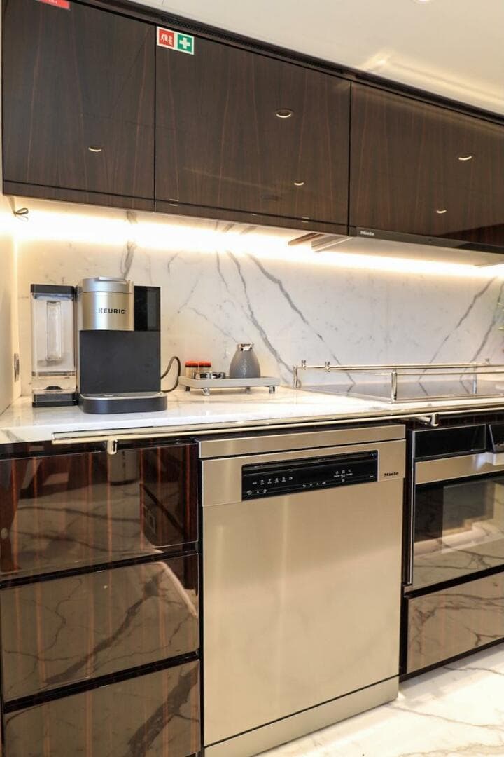 Modern kitchen with marble backsplash, sleek cabinetry, and high-end appliances on a Majesty 120 yacht.