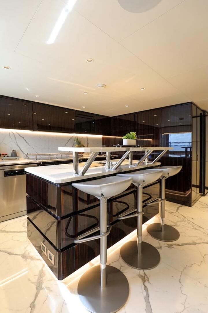 Luxurious 2025 Majesty 120 yacht kitchen with modern bar stools and sleek marble flooring.