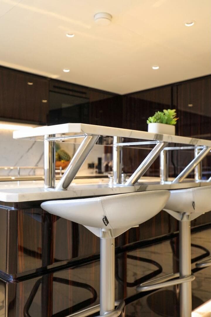 Modern kitchen interior with sleek bar stools and contemporary design, Majesty 120 yacht, 2025 model.