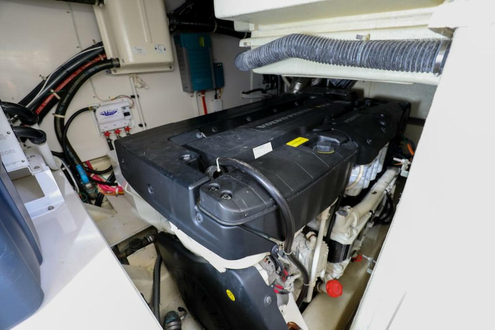 Engine room of 2016 Marquis 660 Sport Yacht, showcasing mechanical components and wiring.