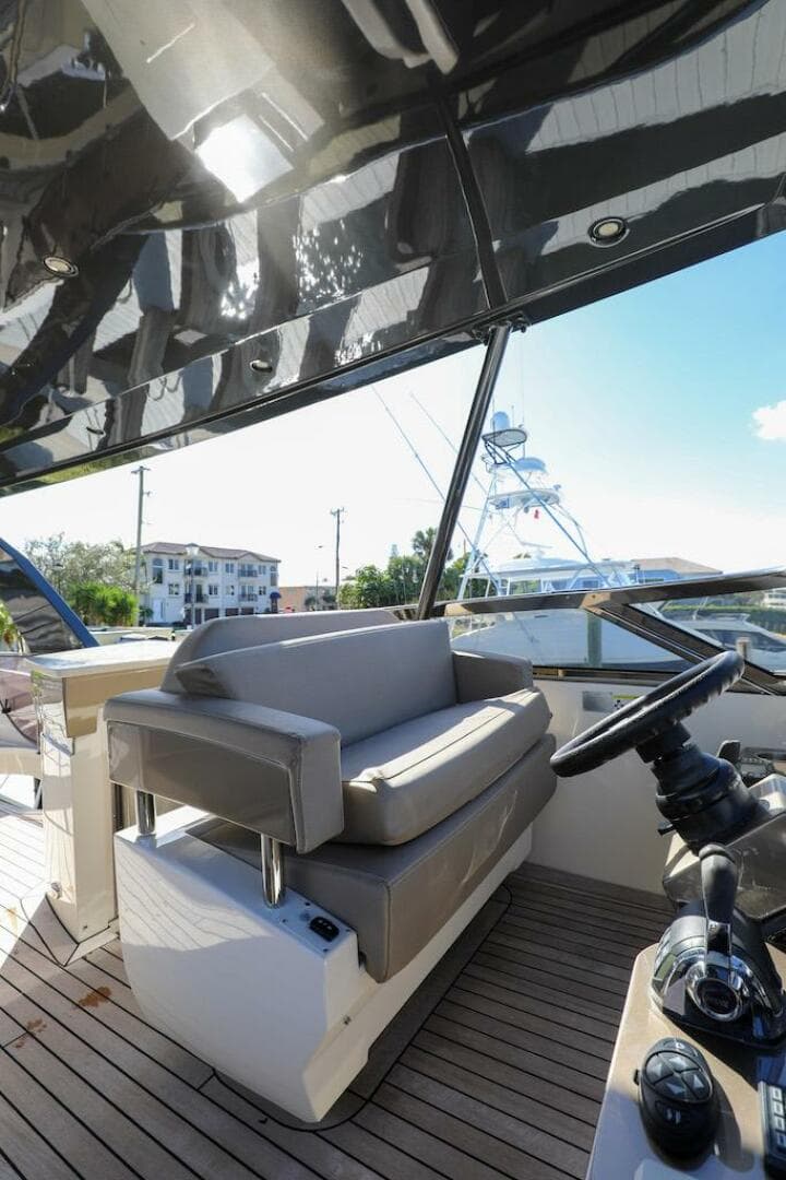 2016 Marquis 660 Sport Yacht helm with cushioned seating and modern controls.