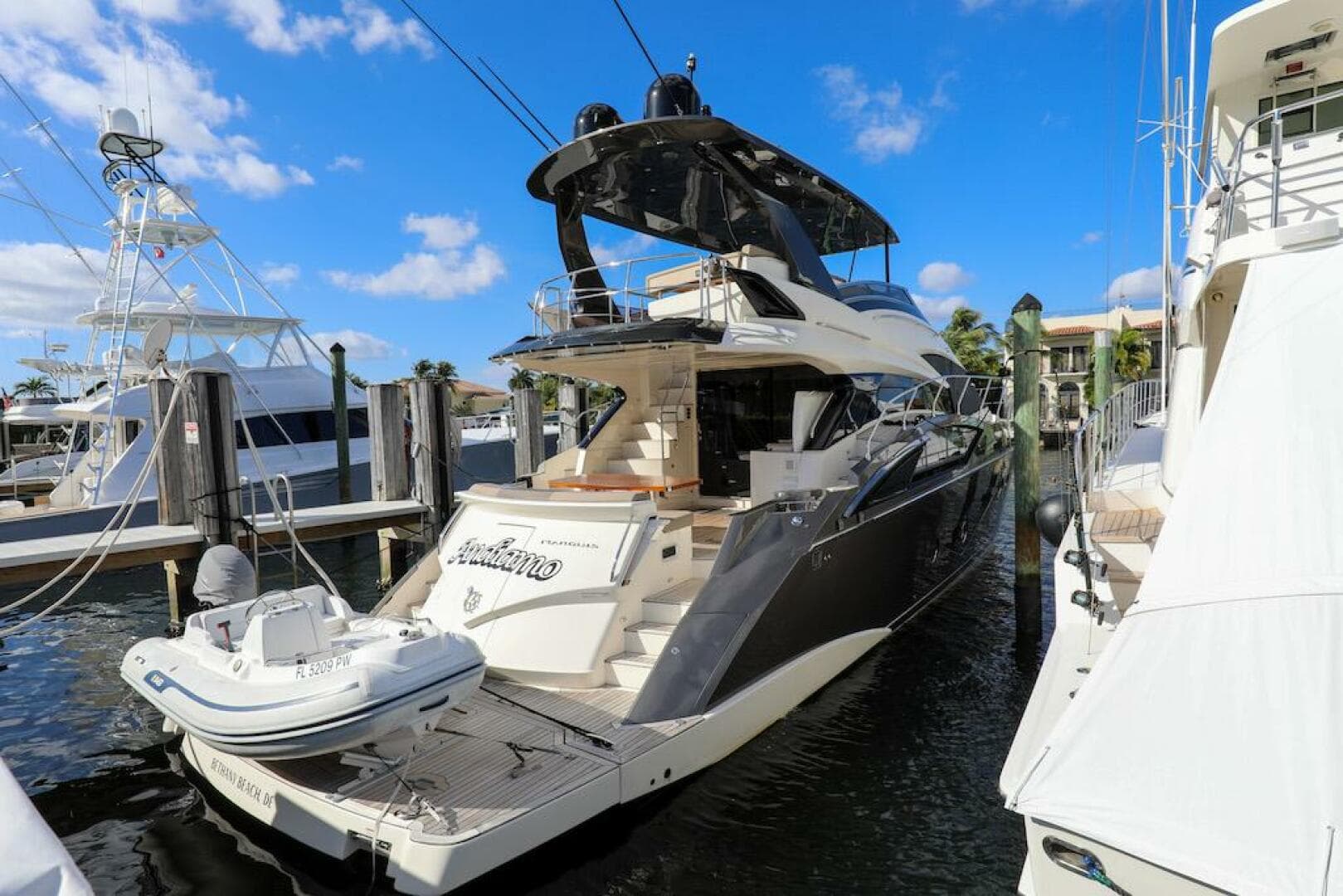 2016 Marquis 660 Sport Yacht docked at marina under clear blue sky.