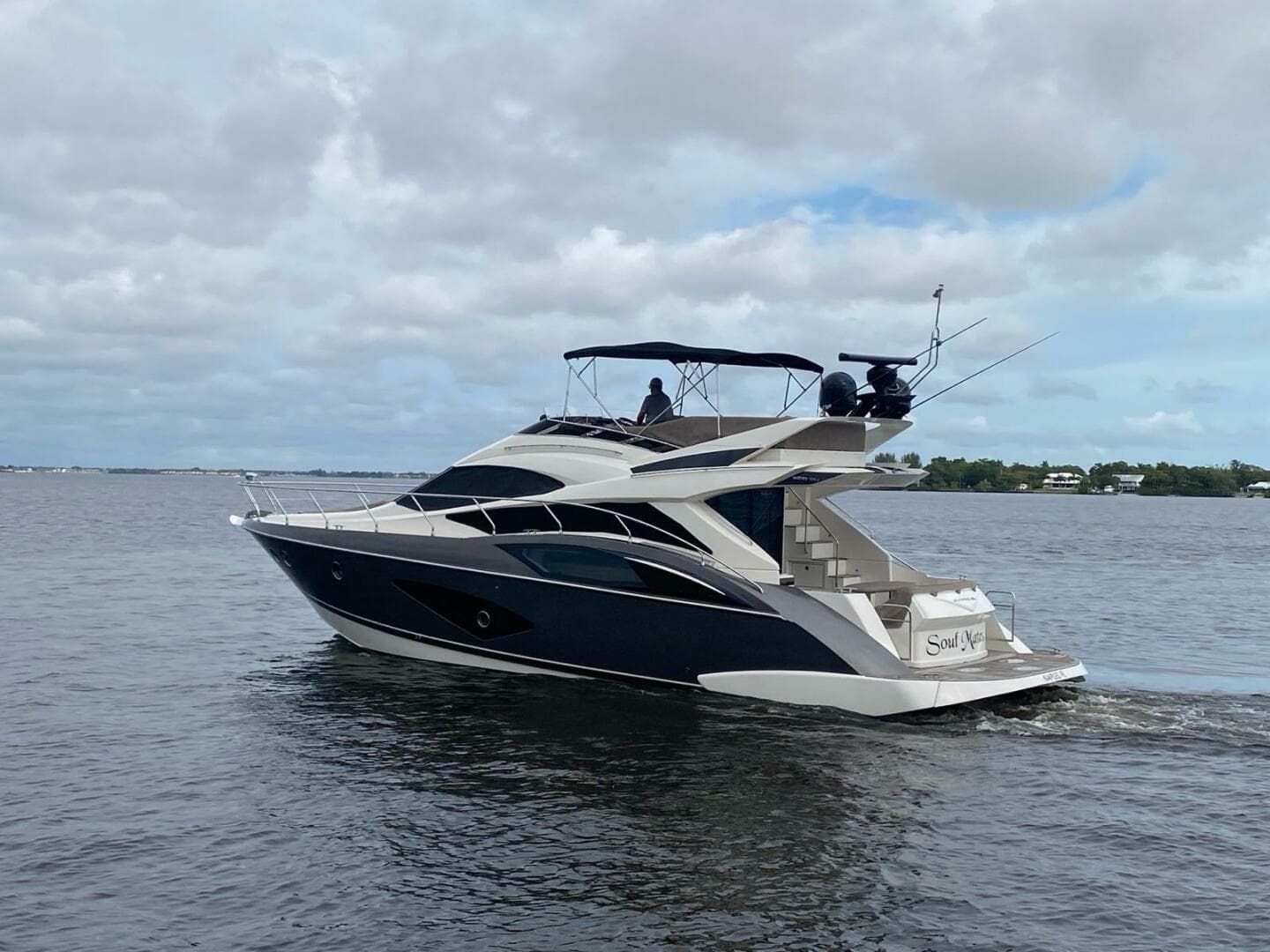 2017 Marquis 500 Sport Yacht cruising on a calm, cloudy day.
