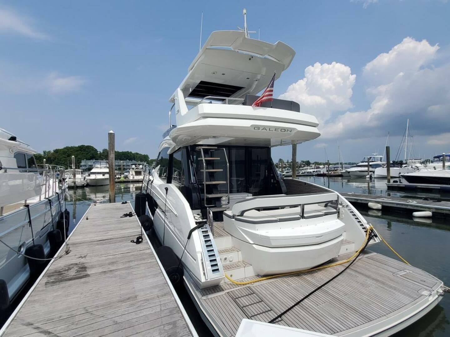 Galeon 500 Fly 2020 yacht docked at marina on a sunny day.
