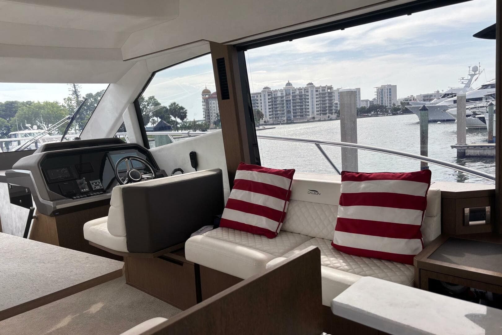 Interior of 2020 Galeon 500 Fly yacht with striped cushions and waterfront view.