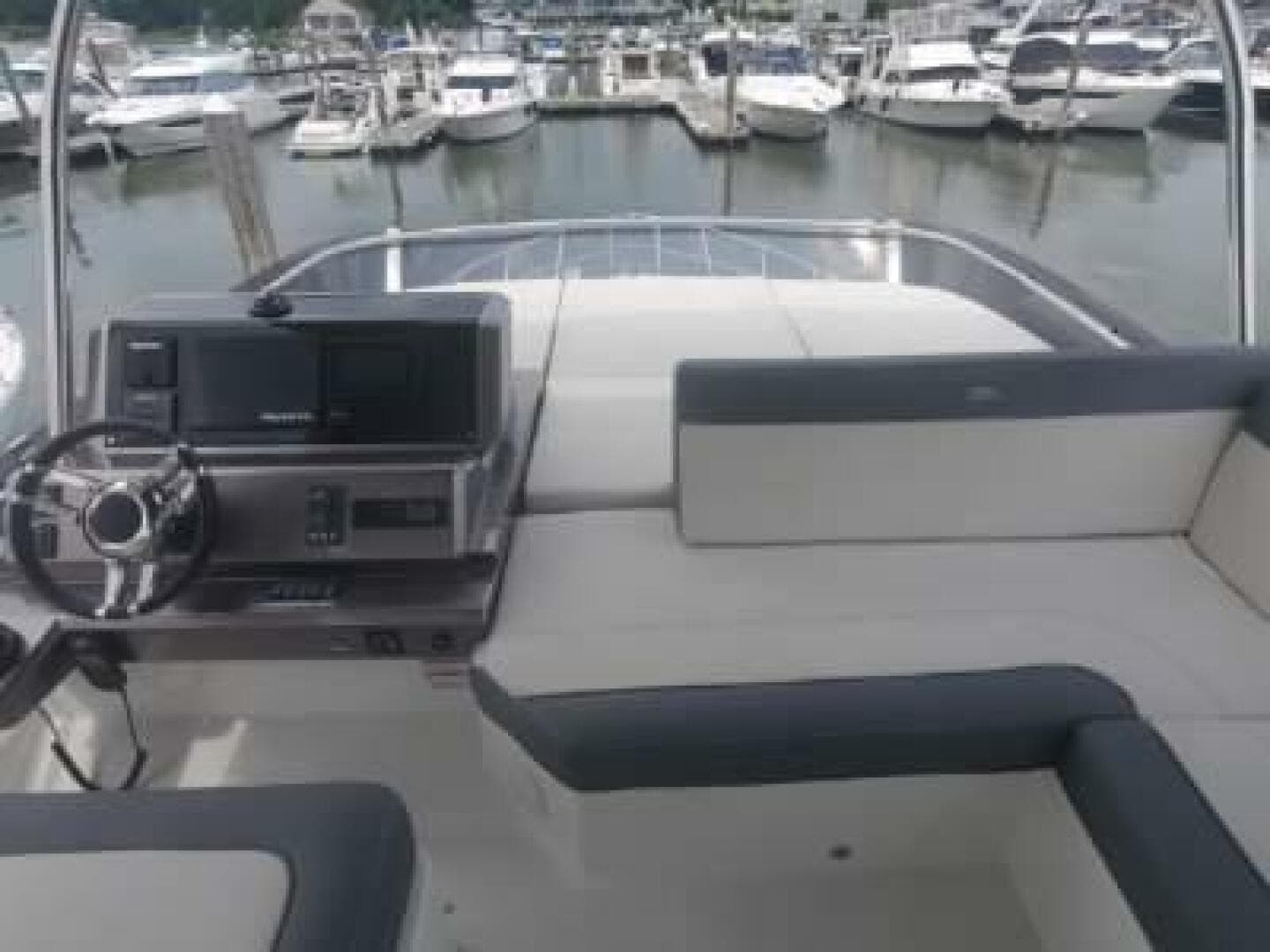 Flybridge of 2020 Galeon 500 Fly yacht with marina in background.
