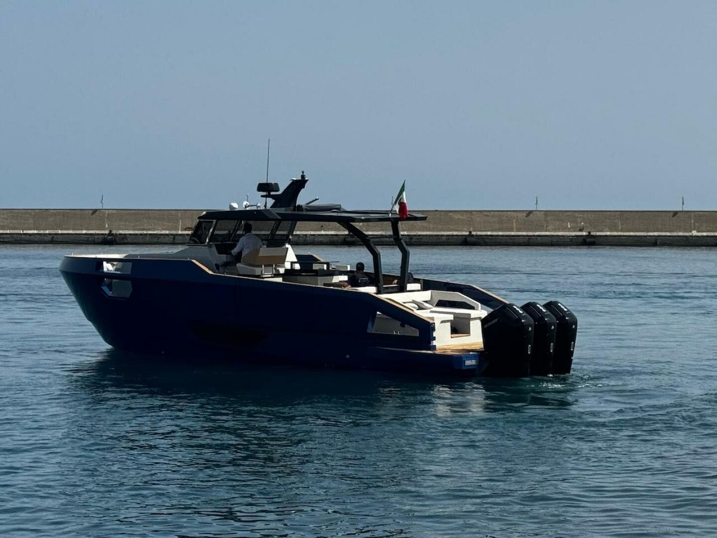 2025 Aicon Audace 50 yacht on calm water near a pier.