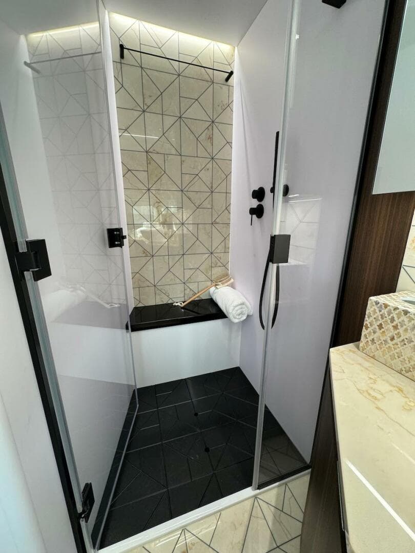 Luxurious shower in 2024 Aicon 66 Vivere yacht with modern geometric tiles.