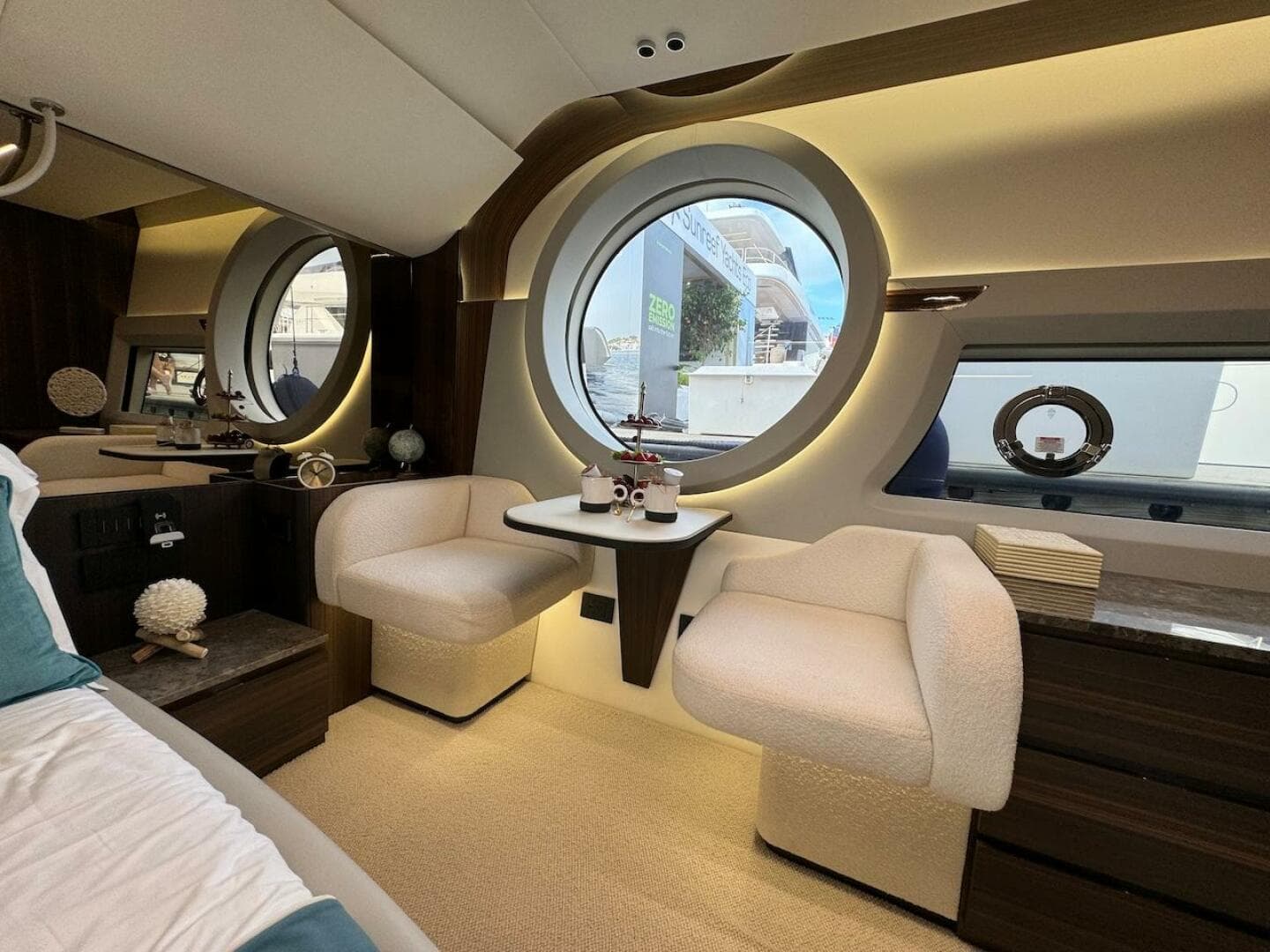 Luxurious interior of 2024 Aicon 66 Vivere yacht with elegant seating and round windows.