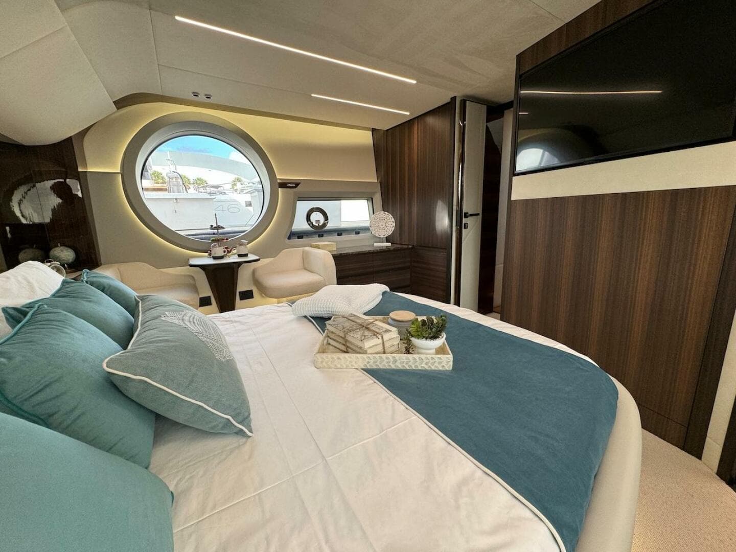 Luxurious bedroom interior of 2024 Aicon 66 Vivere yacht with modern decor and large window.