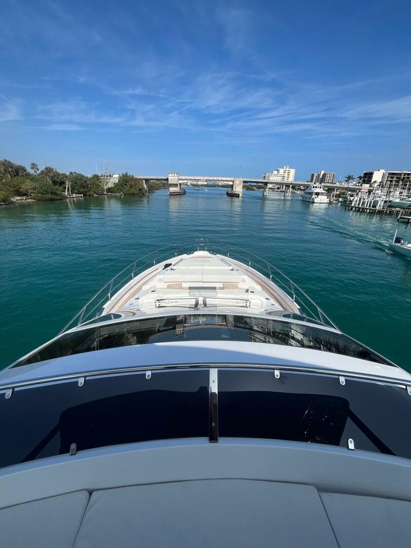 2024 Aicon 66 Vivere yacht cruising in a scenic coastal waterway.