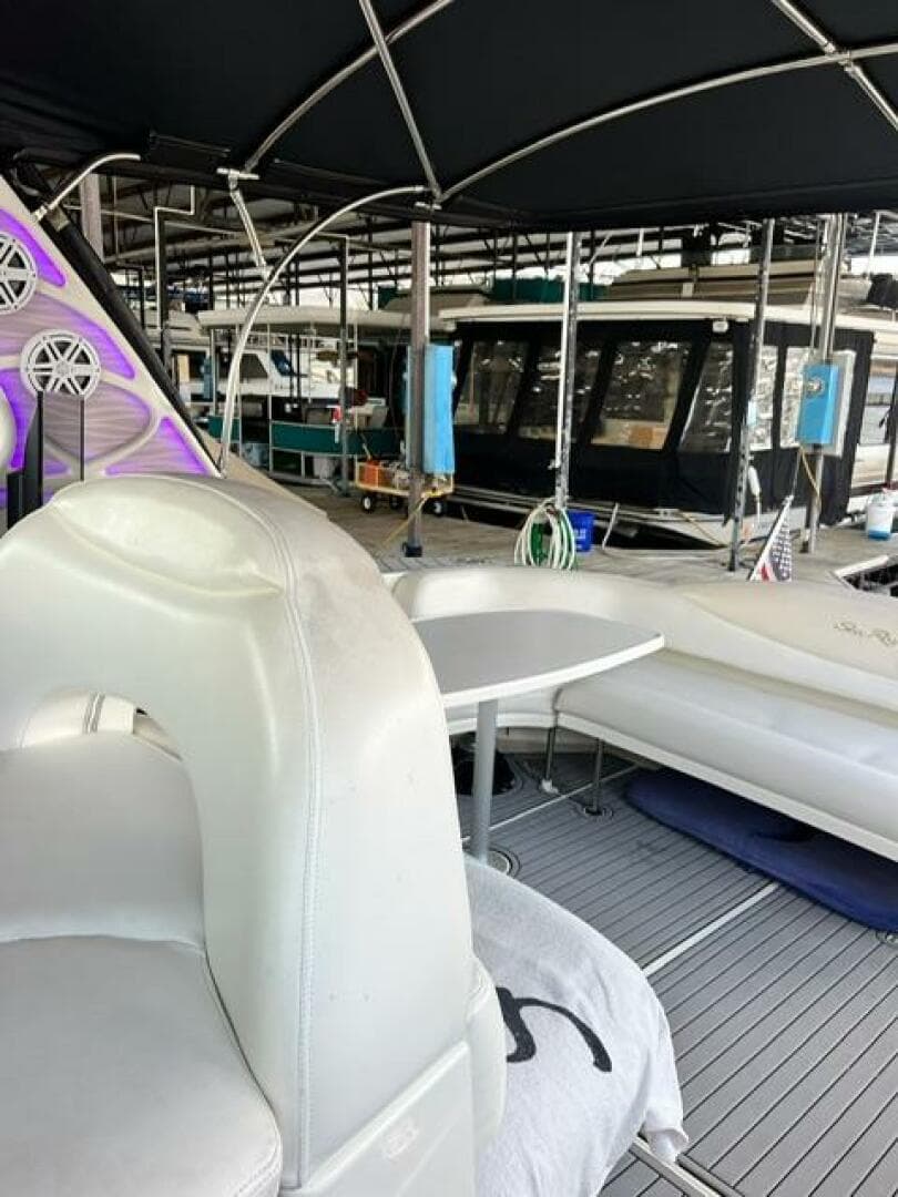 2003 Sea Ray 380 Sundancer interior with seating and table under canopy.