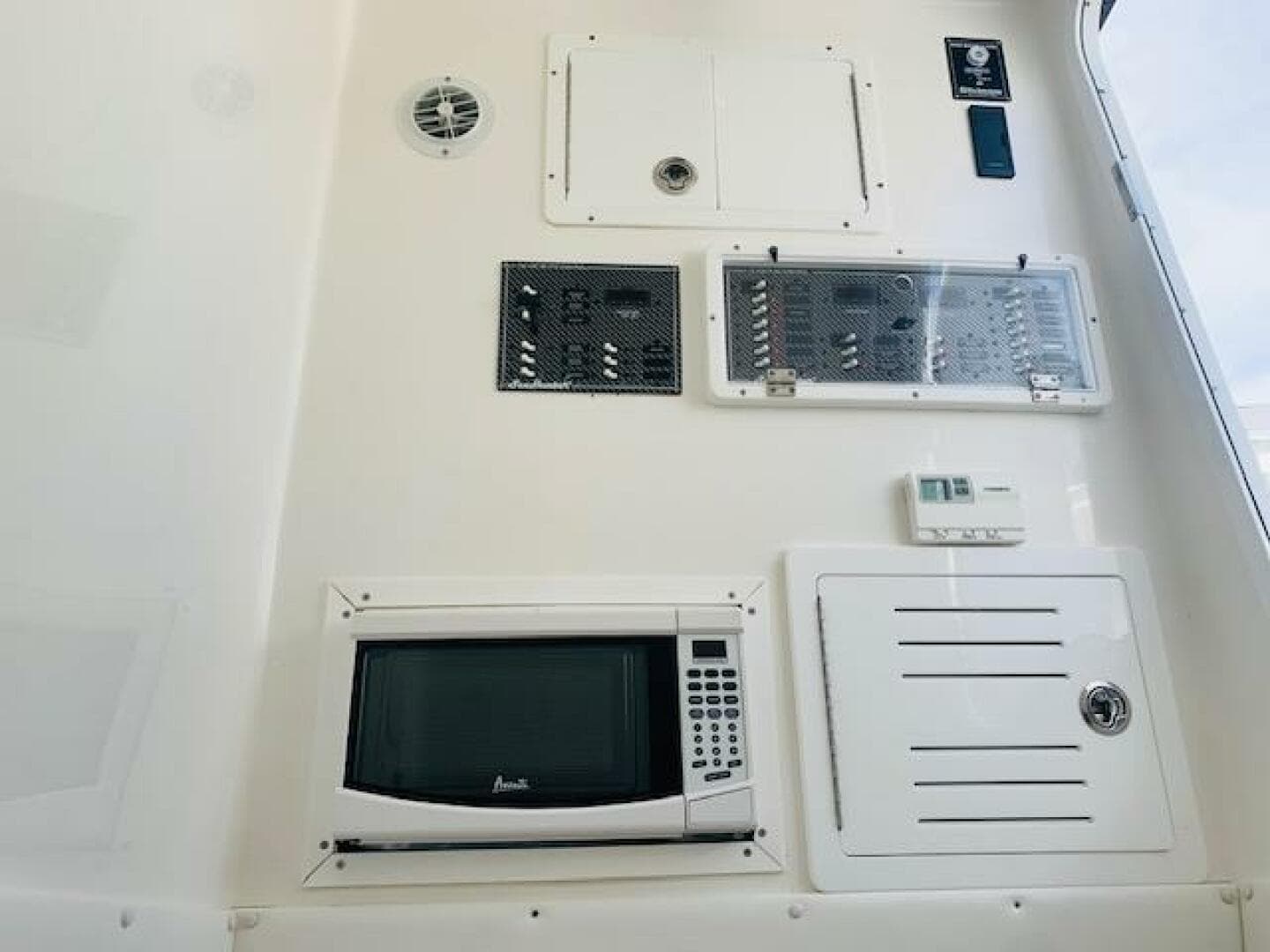 Control panel and microwave on 2020 SeaHunter 39 Tournament boat interior.