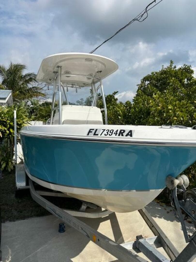 2016 Release 208 RX boat on trailer, blue hull, parked outdoors.