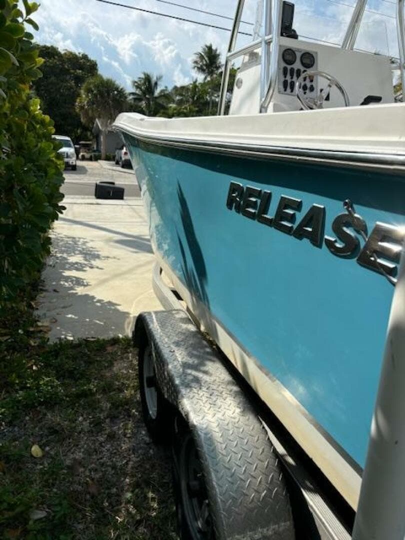 2016 Release 208 RX boat on trailer, blue hull, parked outdoors.