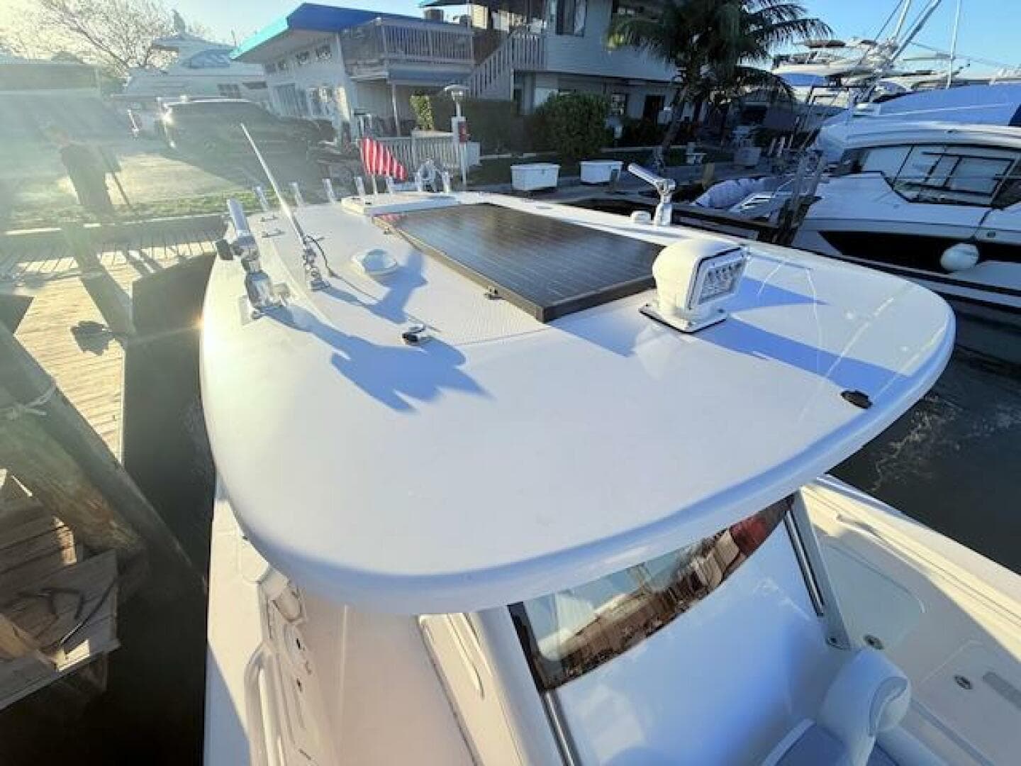 2014 Everglades 355 Center Console boat docked, featuring a sleek white design and modern equipment.