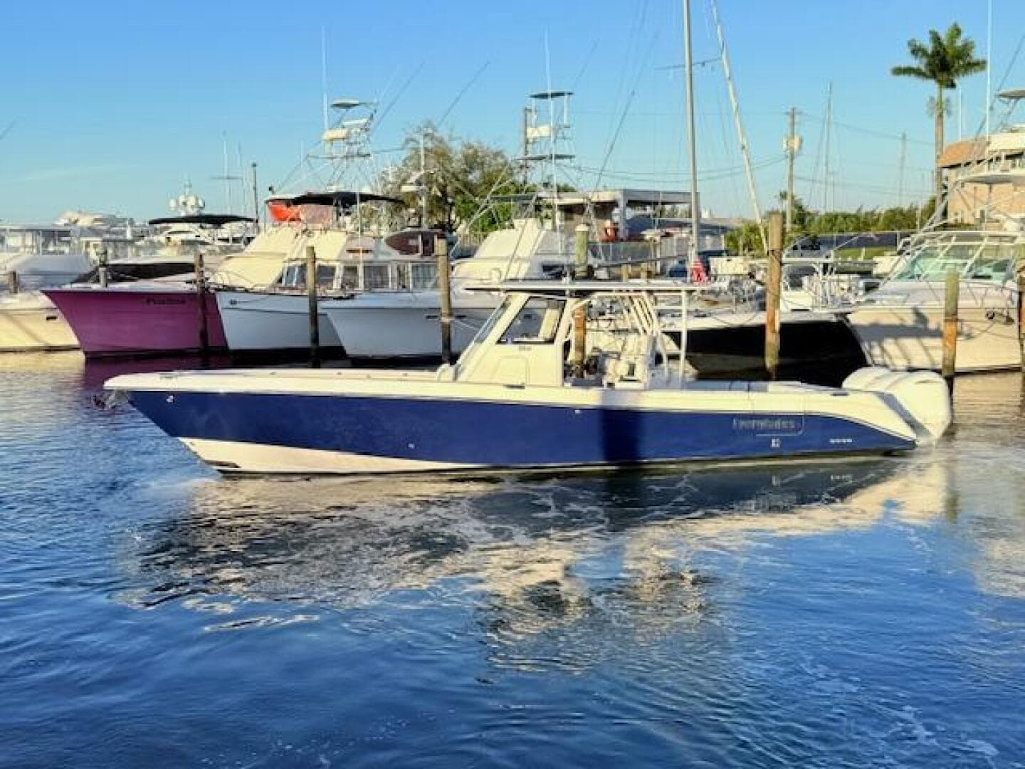 2014 Everglades 355 Center Console boat docked in a marina, surrounded by other vessels.